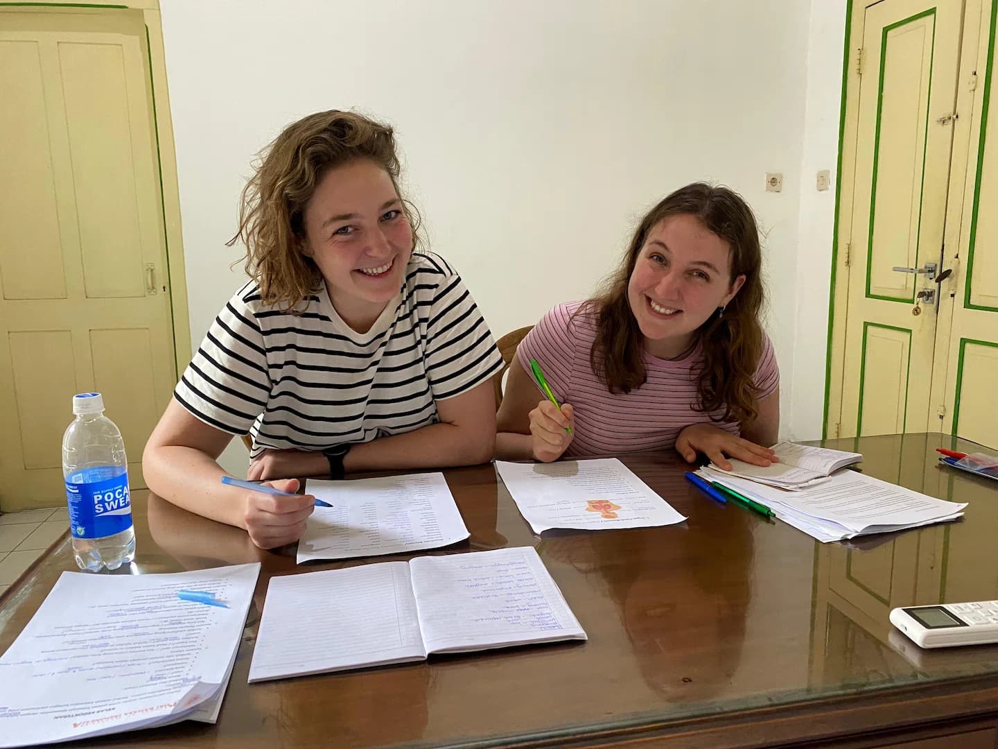 Puri Bahasa students studying together at a desk with notebooks