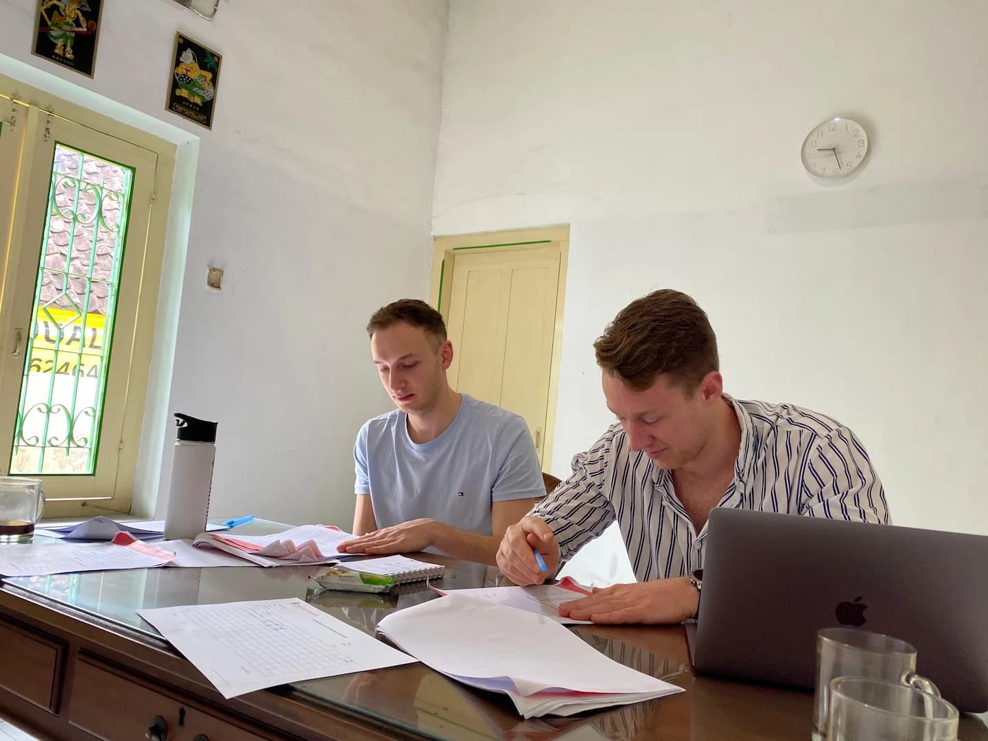 Puri Bahasa students focused on studying with papers and a laptop