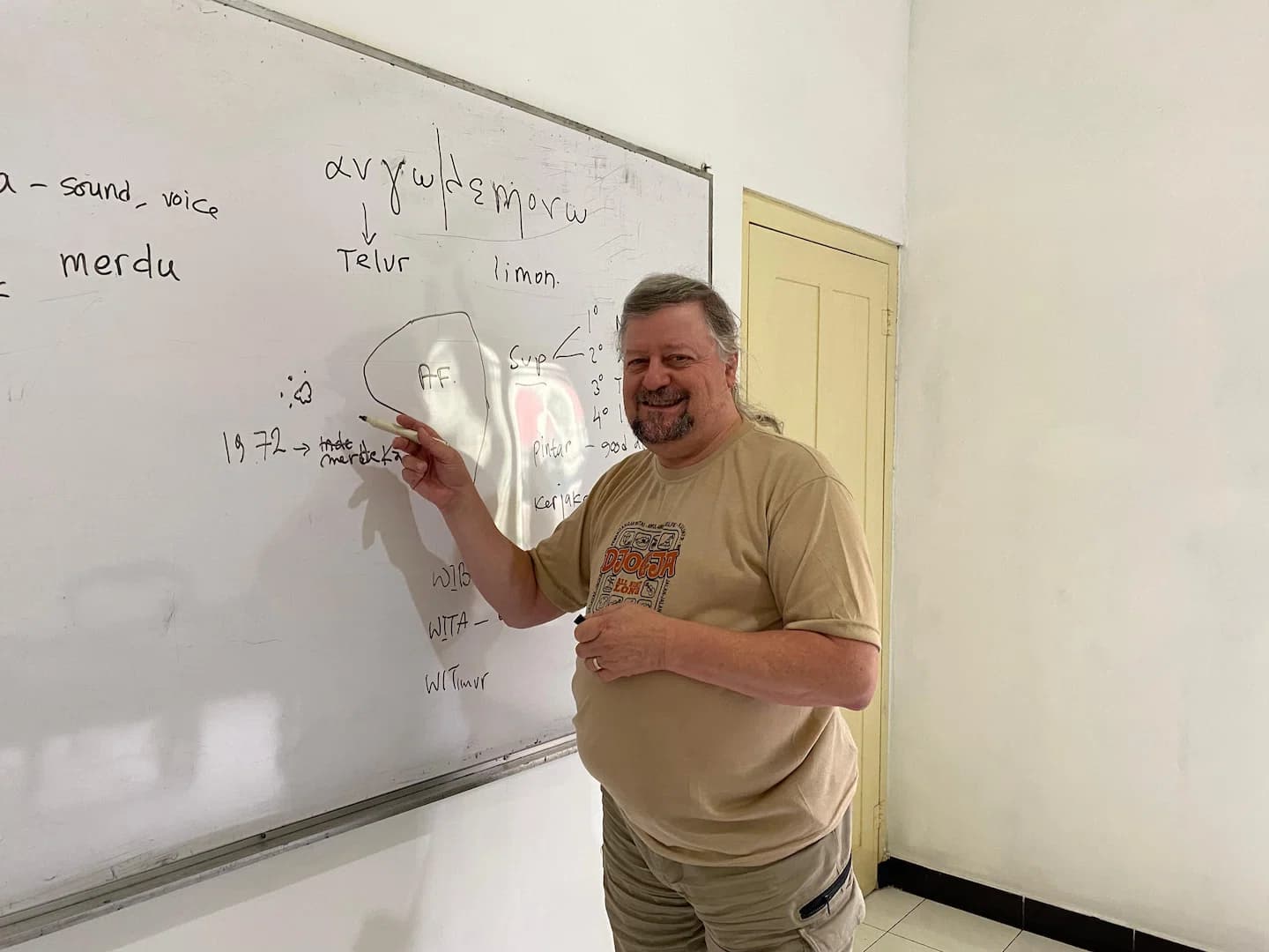 A Puri Bahasa student writing language notes on a whiteboard